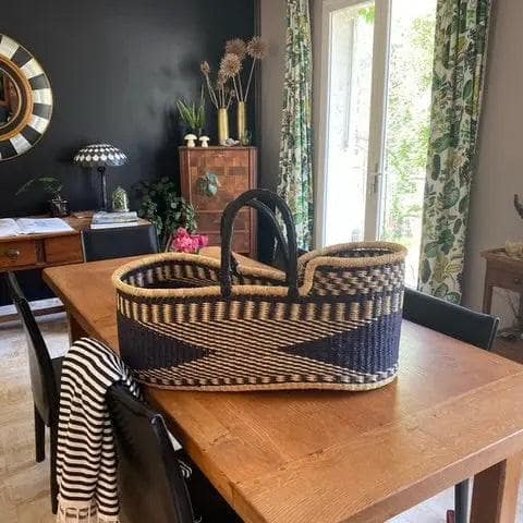 straw  baby bassinet placed in modern nursery with natural decor and soft lighting